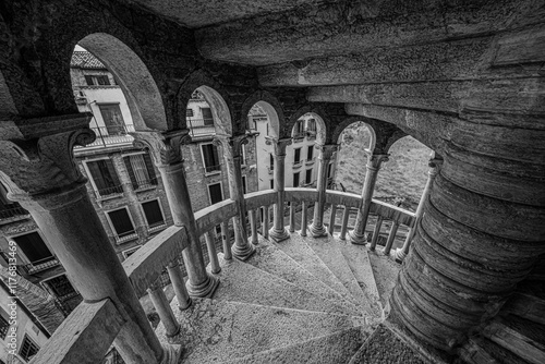 Spiral staircase in Palazzo Contarini del Bovolo surrounded by arches and city view of Venice photo