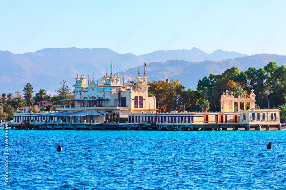 Mondello beach in Palermo, Sicily Italy. Ornate building situated on a pier at seaside, with mountains visible in the background