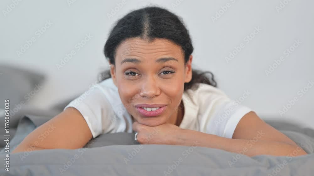 Webcam View of African Woman Doing Video Chat while Lying on Stomach in Bed Webcam View of African Woman Doing Video Chat while Lying on Stomach in Bed