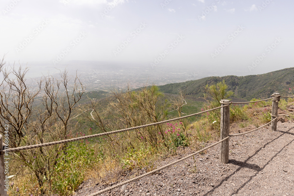 Footpath with a wooden barrier on slope of Mount Vesuvius volcano, Naples, Italy