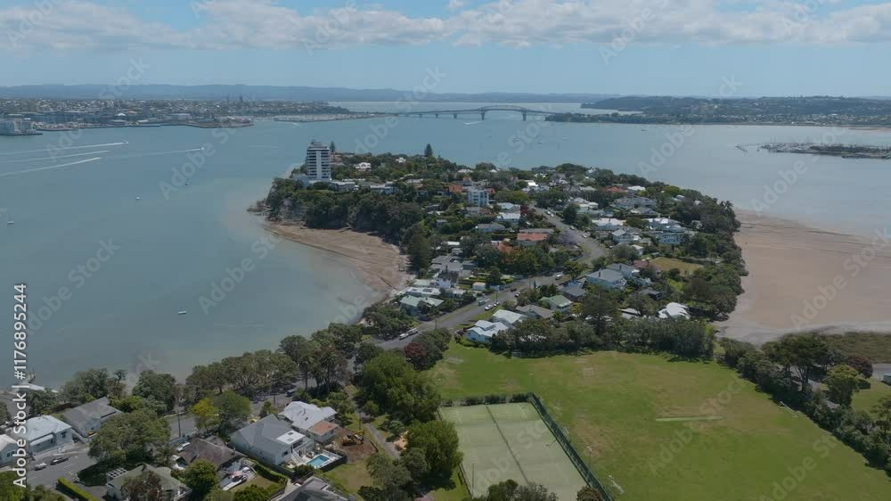 Aerial view of a residential area near a harbor, featuring a park and boats. Coastal town charm. Bayswater, Auckland, New Zealand Aerial view of a residential area near a harbor, featuring a park and boats. Coastal town charm. Bayswater, Auckland, New Zealand