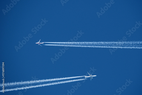 Airplane in the blue sky with contrail. Two planes in the sky.