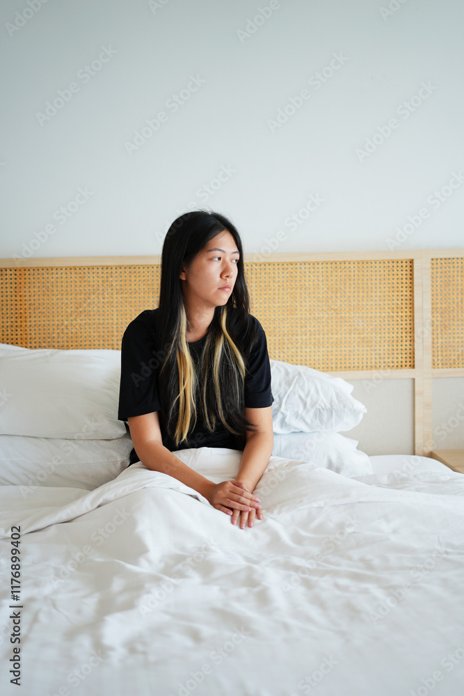Sick young asian woman feeling sad, tired, stressed and worried suffering depression in mental health, sitting and lying on bed, covering her ears and cannot sleep well from insomnia, mental problem. Sick young asian woman feeling sad, tired, stressed and worried suffering depression in mental health, sitting and lying on bed, covering her ears and cannot sleep well from insomnia, mental problem.
