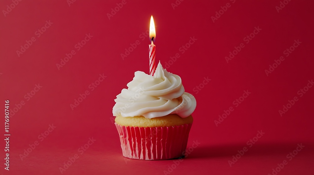 a single cupcake with white frosting and a lit birthday candle, set against a solid red background. a single cupcake with white frosting and a lit birthday candle, set against a solid red background.