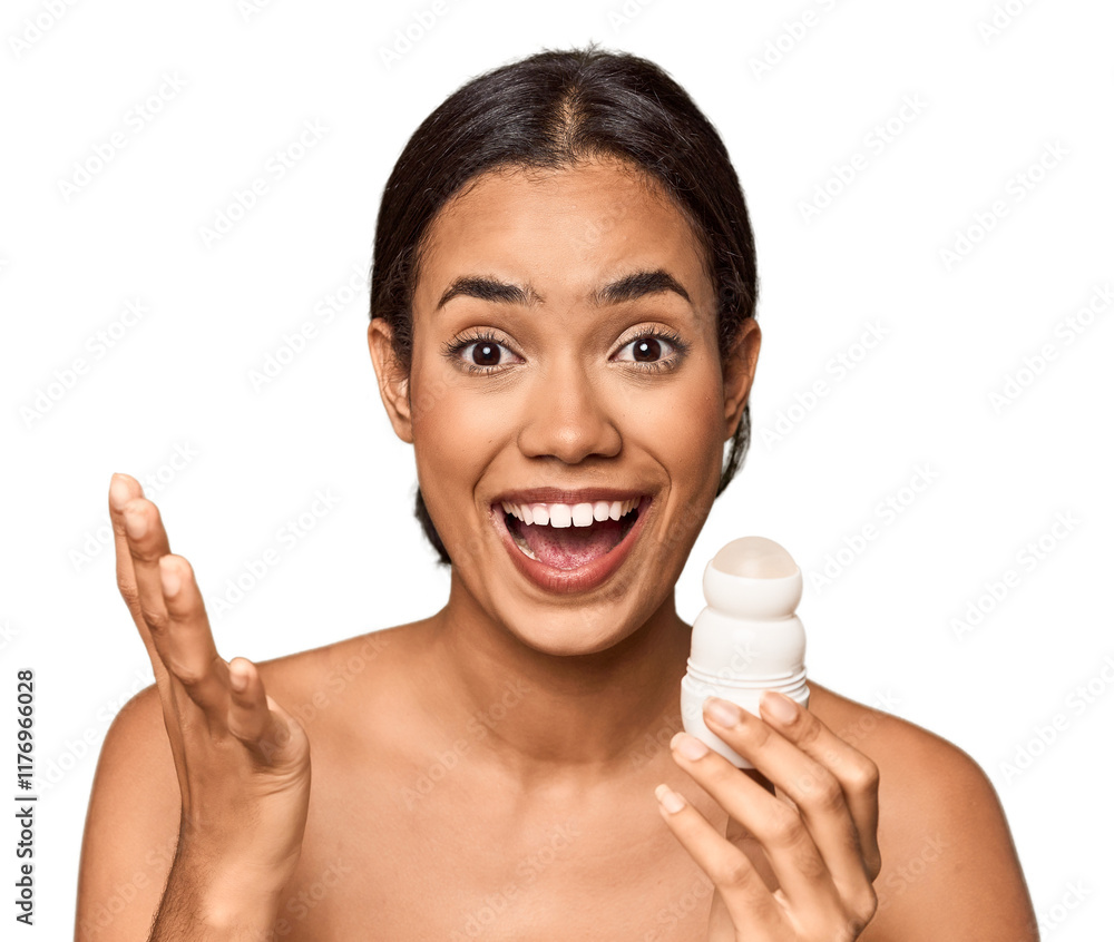Filipino woman holds deodorant in studio receiving a pleasant surprise, excited and raising hands. Filipino woman holds deodorant in studio receiving a pleasant surprise, excited and raising hands.