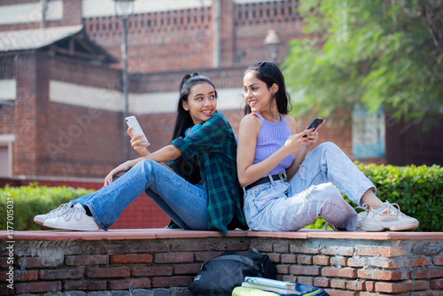 Two Siblings Are Looking At Each Other While Holding Phones in Their Hands