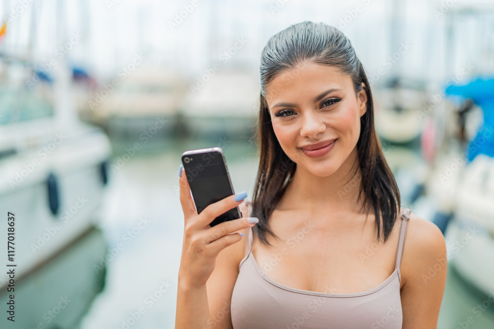 Young pretty woman using mobile phone at outdoors smiling a lot Young pretty woman using mobile phone at outdoors smiling a lot
