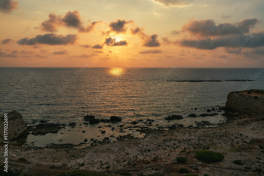 Fototapeta premium Rocky Shoreline at Methoni Fortress During Sunset