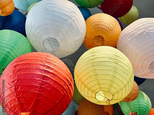 Colorful lanterns made from paper are hanging in the room. 