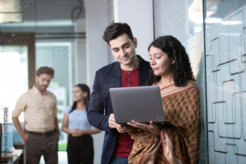 Senior Sales Manager And Employee Discussing Over Laptop