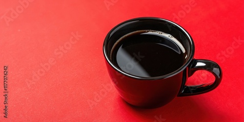 A single serving of dark roasted coffee in a black mug on a red surface photo