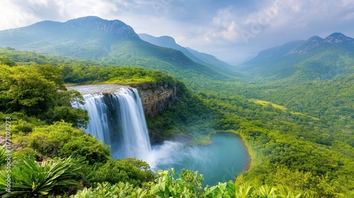A wide panoramic view of a lush, green tropical jungle with a stunning waterfall cascading down into a crystal clear pool, surrounded by vibrant foliage and towering trees.