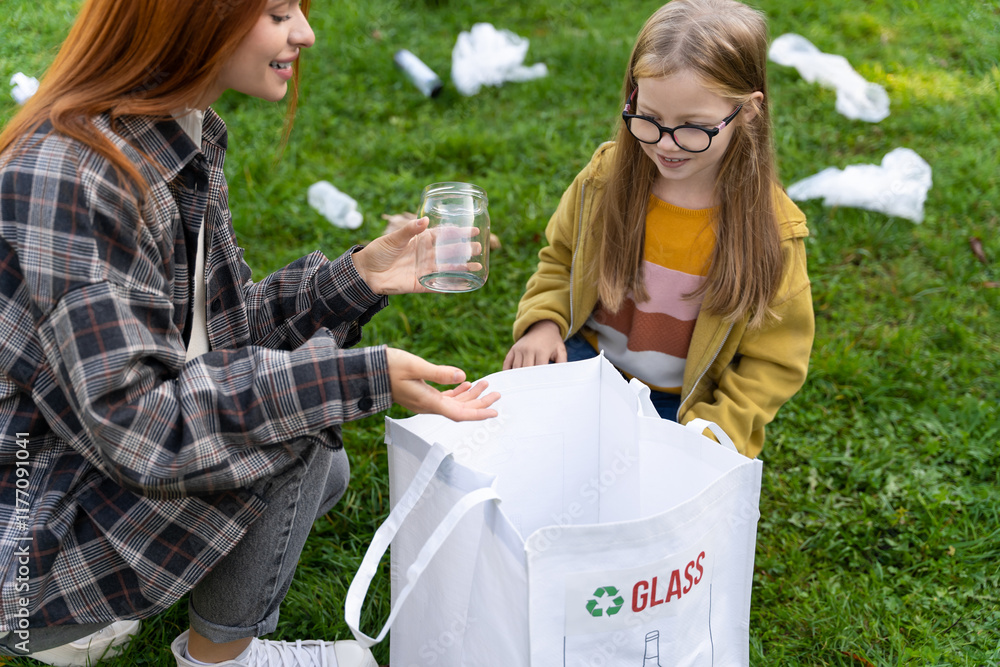 Fototapeta premium Teacher guiding child in collecting glass waste in park to reduce pollution
