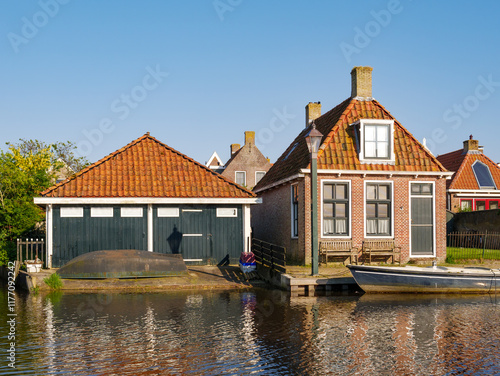 House with boathouse along Zijlroede canal in old town of Hindeloopen, Friesland, Netherlands