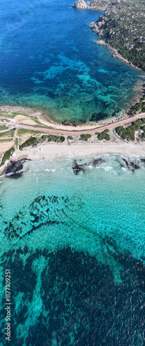 Canvas Print The isthmus connecting Capo Testa to mainland Sardinia, featuring turquoise waters, sandy beaches, and a coastal road surrounded by lush greenery and rocky shores