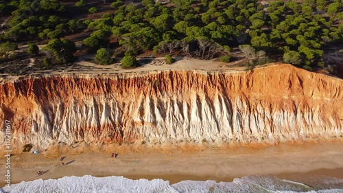 Drone going backwards above Falesia Beach. Beautiful landscape in south of Portugal, Algarve Region. Sunset point, empty natural beach, Turquoise water colour photo