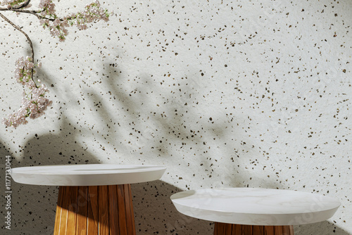 Obraz na płótnie A marble round table for presenting products against the background of a concrete wall surrounded by greenery. Shadows of sunlight on the wall. Background for the presentation of cosmetic products w salonie