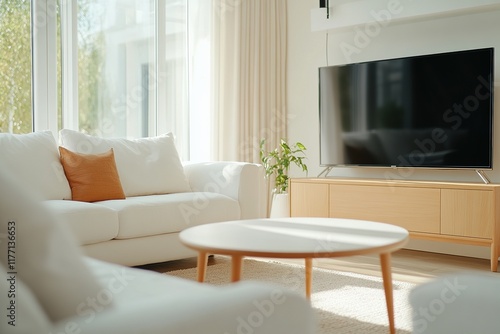 Modern living room with cozy seating and large TV in a bright, airy space during daylight hours
