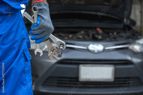 Close up car mechanic hand holding mechanic tools working in auto repair service shop photo