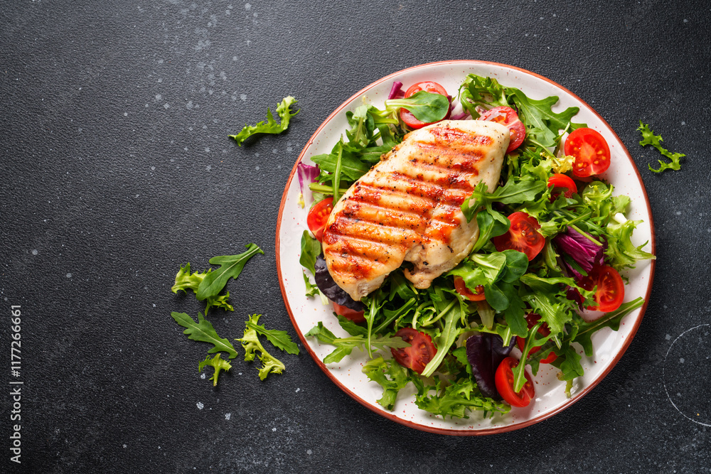 Dash diet food, healthy nutrition. Chicken steak with fresh salad on black background. Top view with copy space.