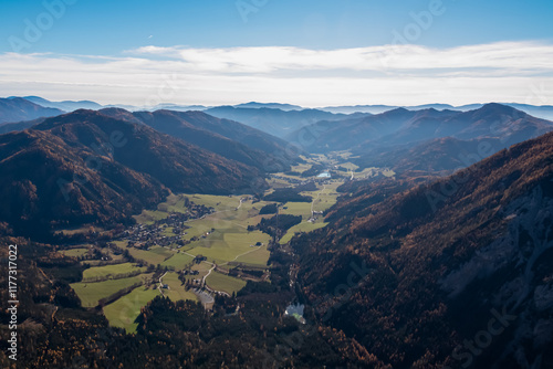 Aerial view of Kreuzteich lake seen from top of mount Pribitz in Hochschwab mountains in Styria, Austria. Rolling hills covered in deciduous trees in vibrant autumn colors. Wanderlust Austrian Alps photo