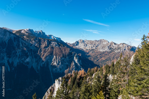 Scenic view of mountain peak Hochturm in Hochschwab region, Styria, Austria. Steep rocky cliffs covered in deciduous trees in vibrant autumn colors. Wanderlust Austrian Alps. Golden coniferous forest photo