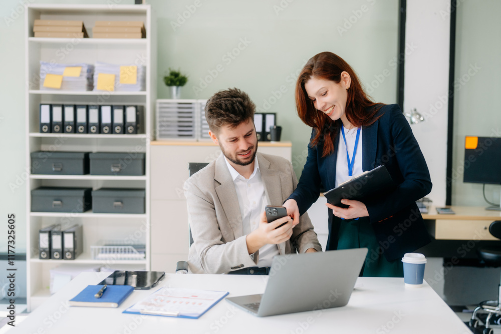 Fototapeta premium Two business workers talking on the smartphone and using laptop