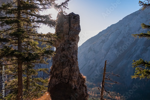 Unique rock formation in mountain landscape in Hochschwab Alps, Styria, Austria. Shaped like pillar or totem pole, stands tall against backdrop. Towering mountains and dense forests in Austrian Alps photo