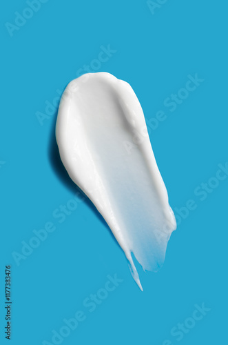 A sample of white cosmetic moisturizer on a blue background photo