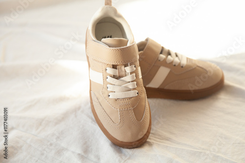 Foto Beige children's sneakers with velcro straps and white stripes