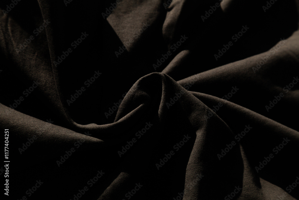 Fototapeta premium Draped dark fabric texture. Rich, deep shadows and subtle folds create a luxurious, elegant feel. Perfect for fashion, design, or background.