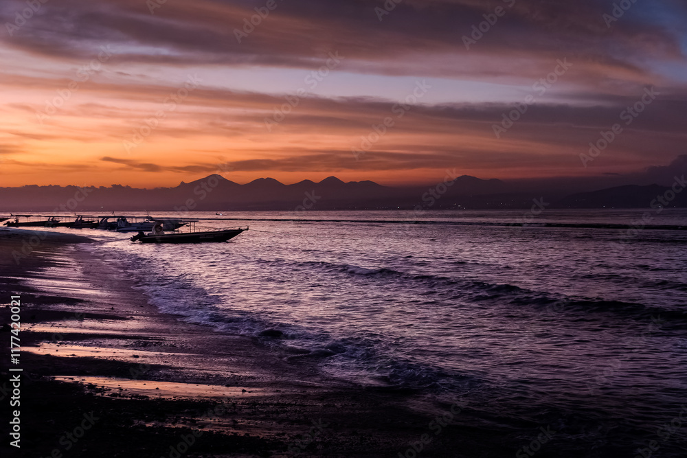 Obraz premium Summer vacation or holiday landscape. Tropical island sunset beach view mountains silhouette under calm sky sea and boats