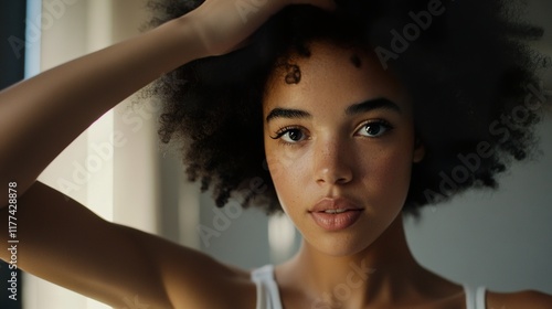 Woman standing in front of mirror, carefully examining her hair with a thoughtful expression. Reflection and self-awareness in personal grooming and beauty routines. photo