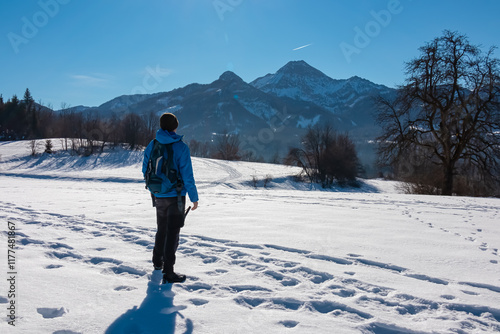 Obraz na płótnie Active man on snow covered alpine meadow with panoramic view of majestic snow-capped mountain peaks Karawanks in Carinthia, Austria. Snow shoeing in winter wonderland near Villach, Austrian Alps w salonie