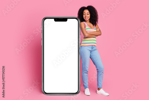 Full length photo of positive funky lady dressed striped tank top arms foled device empty space isolated pink color background photo