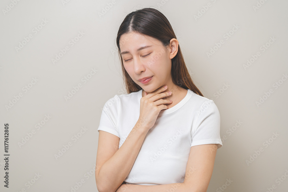 Sickness in inflaming asian young woman, girl use hand check self touch at sore throat, pain thyroid gland on neck or disease reflux, acid of suffer people on wall background. Medical and healthcare. Sickness in inflaming asian young woman, girl use hand check self touch at sore throat, pain thyroid gland on neck or disease reflux, acid of suffer people on wall background. Medical and healthcare.