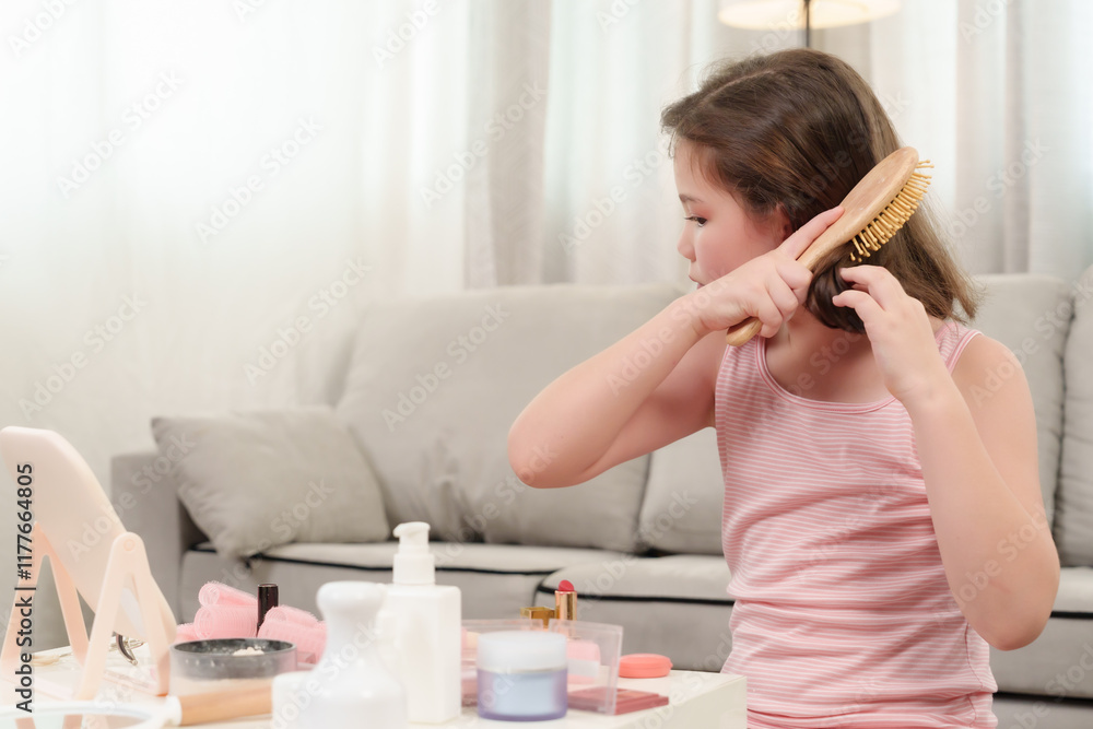 Young girl using brush on hair during creative beauty activity in cozy home setting. Playful moment highlighting childhood curiosity, self-expression, and learning hairstyling techniques. Young girl using brush on hair during creative beauty activity in cozy home setting. Playful moment highlighting childhood curiosity, self-expression, and learning hairstyling techniques.
