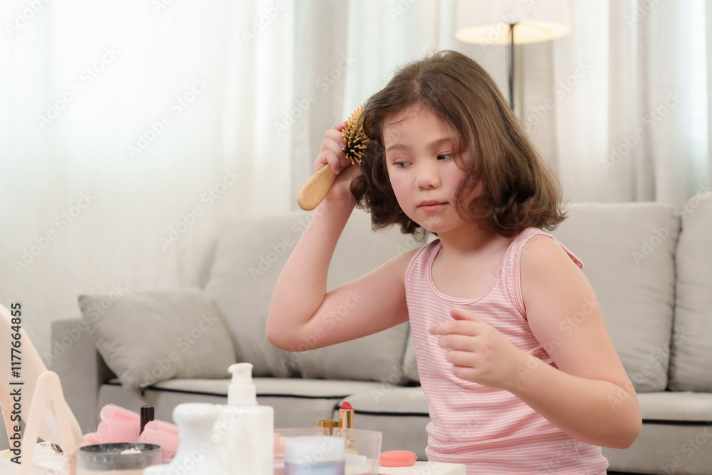 Young girl brushing her hair with focus during playful beauty session at home. Depicting childhood learning, self-expression, and hairstyling practice in a relaxed and creative atmosphere. Young girl brushing her hair with focus during playful beauty session at home. Depicting childhood learning, self-expression, and hairstyling practice in a relaxed and creative atmosphere.