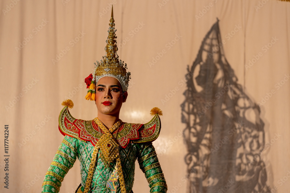 One man with Khon or Mask dance dress stand with performance action in front of grand shadow play in the background with white screen. One man with Khon or Mask dance dress stand with performance action in front of grand shadow play in the background with white screen.