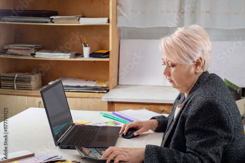 Accountant working at a laptop in the office among documents photo