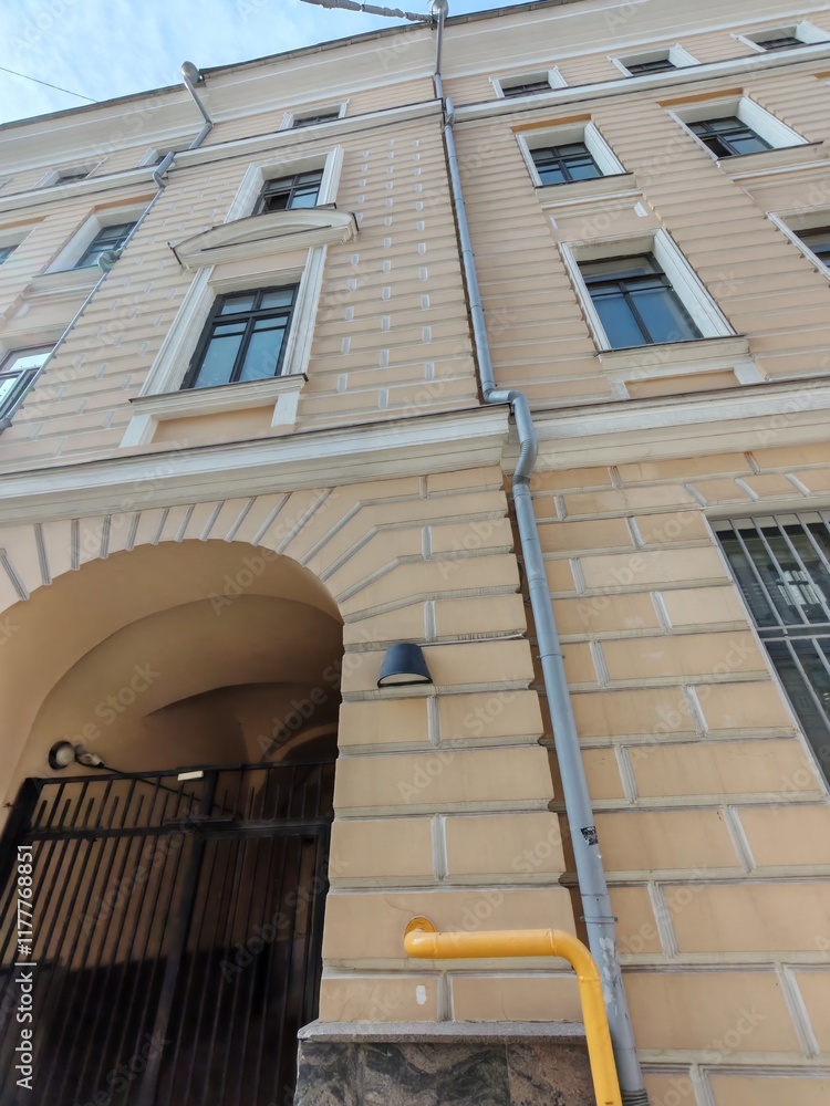 Fototapeta premium A historic building with decorative stone patterns, arched entryways, and metal gates. This image captures the blend of classical design and functional urban elements