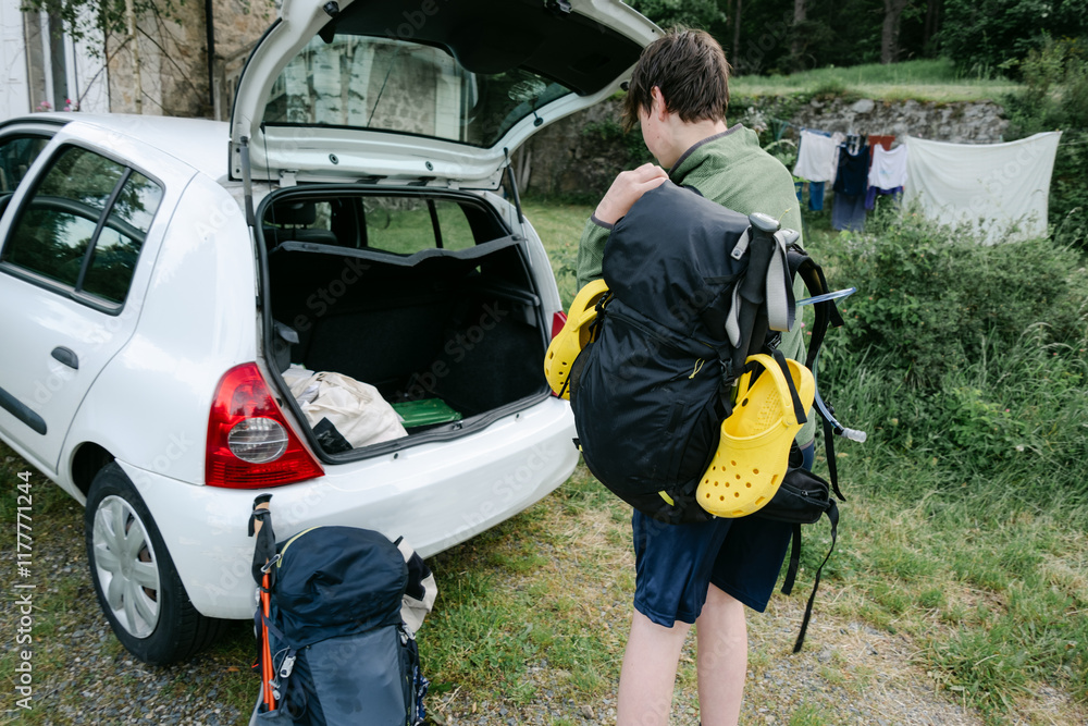 teen putting stuff in a car ready to leave teen putting stuff in a car ready to leave
