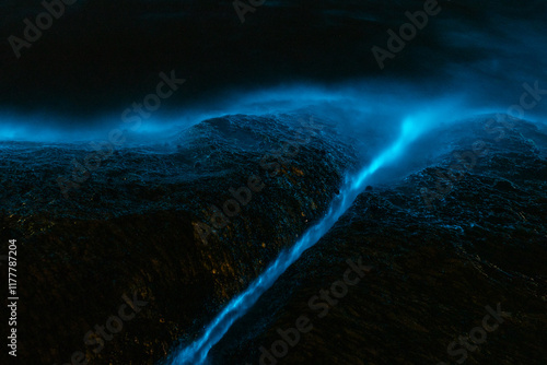 Bioluminescence from micro marine organisms. Shallow water on rocks. 