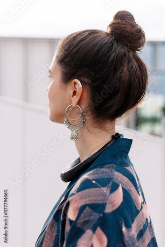 A woman with a stylish bun and large earrings closeup photo