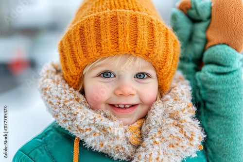 Smiling caucasian child in winter clothes with orange beanie and scarf outside