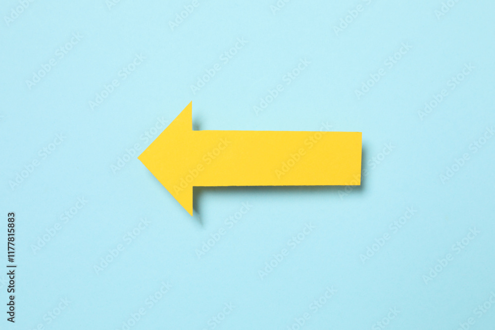 Paper arrow on color background, top view