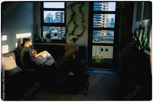 Lady enjoys sunny afternoon sitting in an armchair in her London home photo