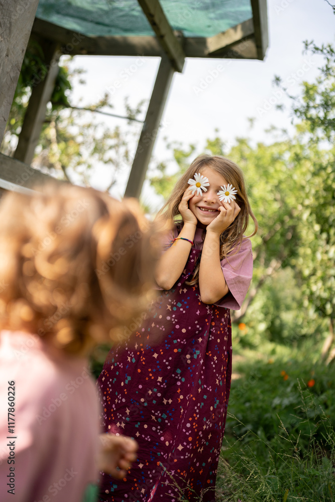 A cute little blonde girl using daisies as her eyes. A cute little blonde girl using daisies as her eyes.