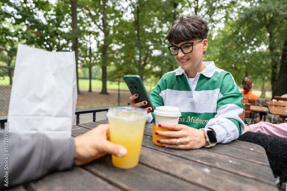 Woman using smartphone while having lunch in manhattan park Woman using smartphone while having lunch in manhattan park