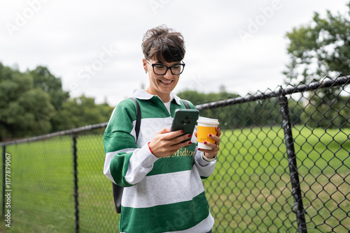 Student using smartphone and drinking coffee photo